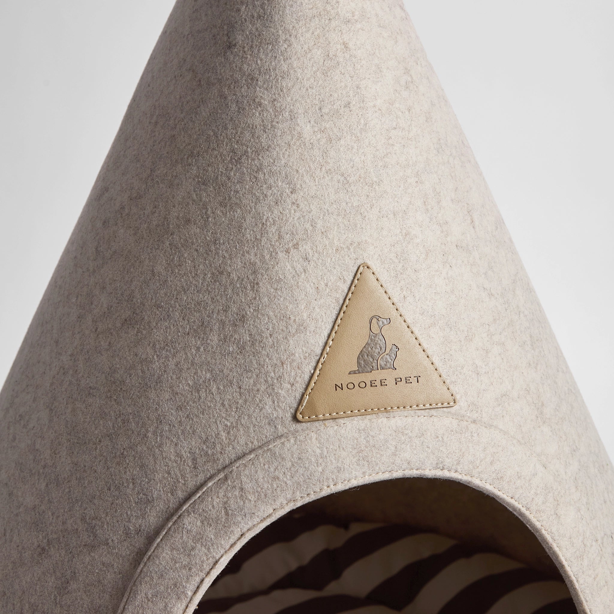 Close-up of the Nooee Pet Buddy Cave in Cream, highlighting the logo and entrance.