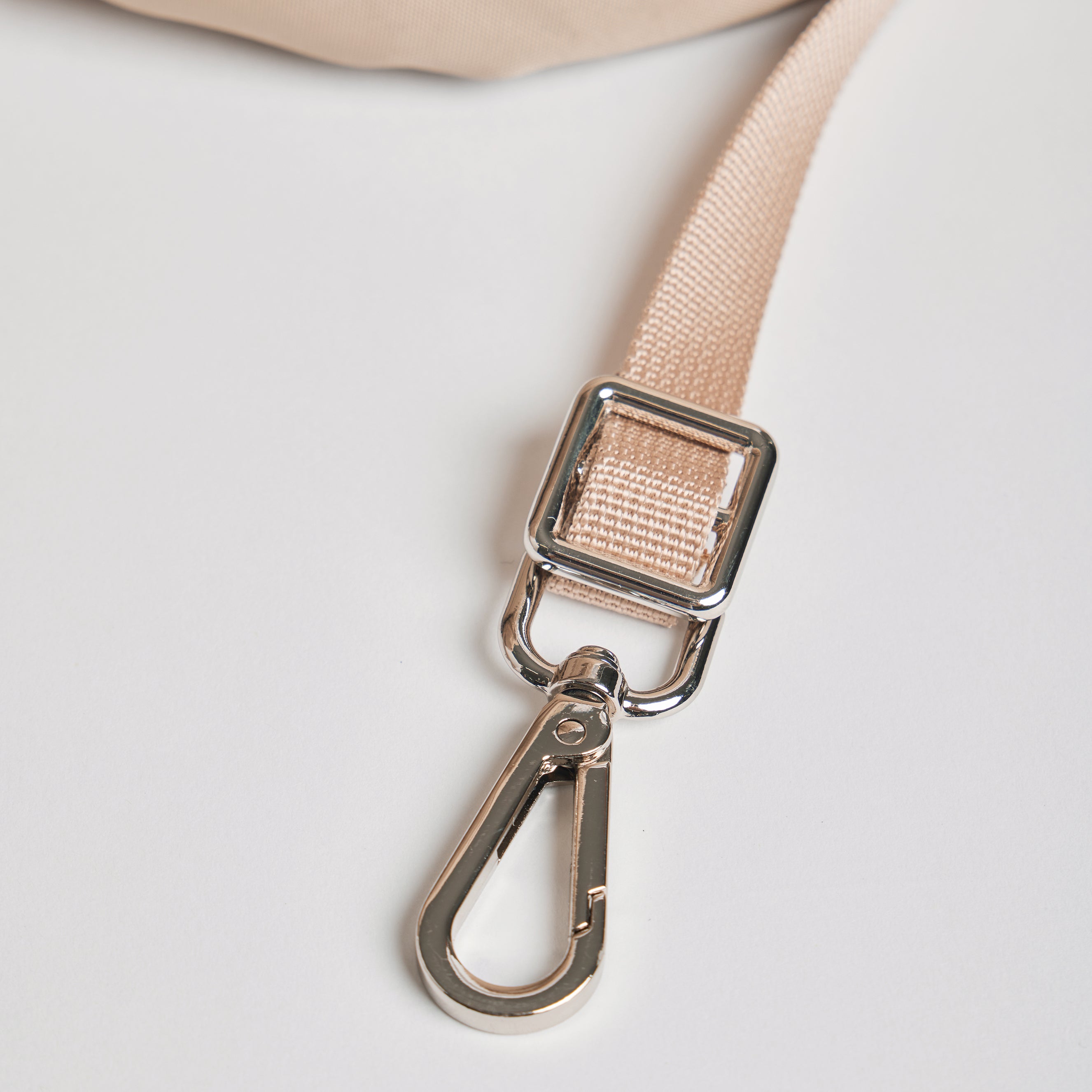 Close-up of the inner safety tether on the Nooee Pet Lola Car Seat, featuring a beige strap and silver metal clip for secure pet attachment during travel.