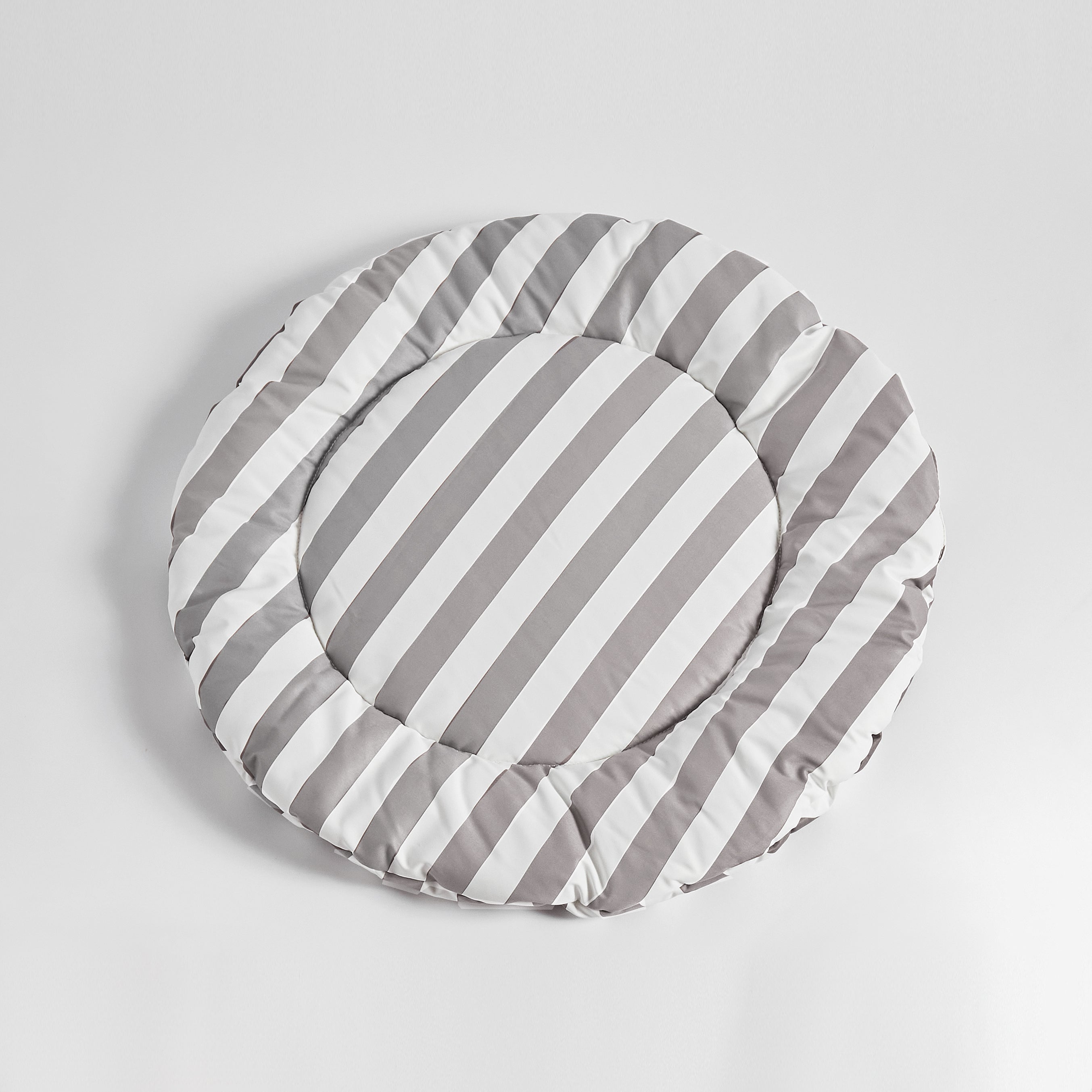 Flat-lay of Nooee Pet Replacement Cushion in gray and white stripes, featuring a soft, round design ideal for refreshing your pet’s cave or using as a cozy mat anywhere.