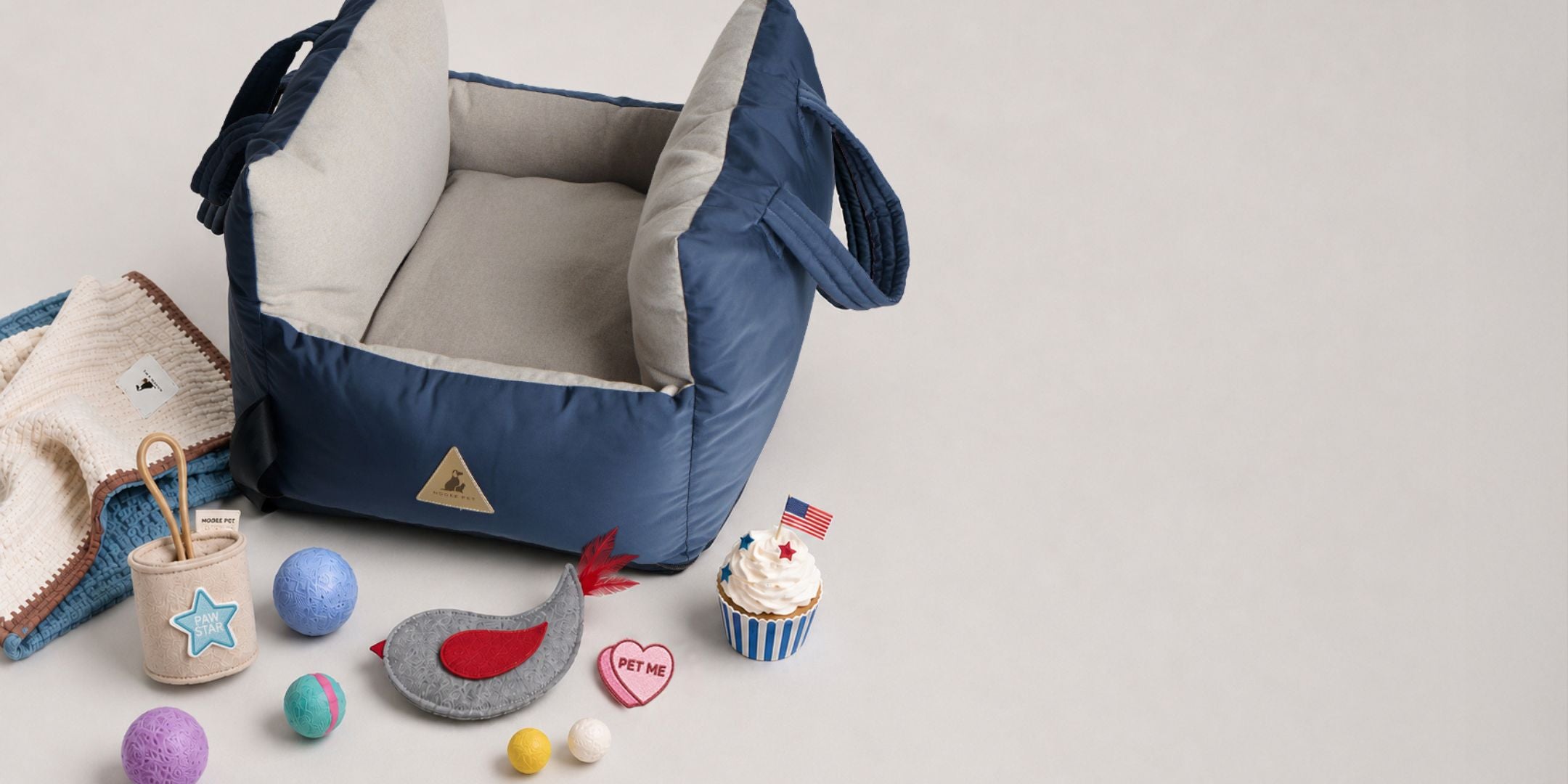 Nooee Pet Charlie navy dog car seat with blanket, toy, Paw Star patch, and Pet Me patch in a July 4th weekend sale display.