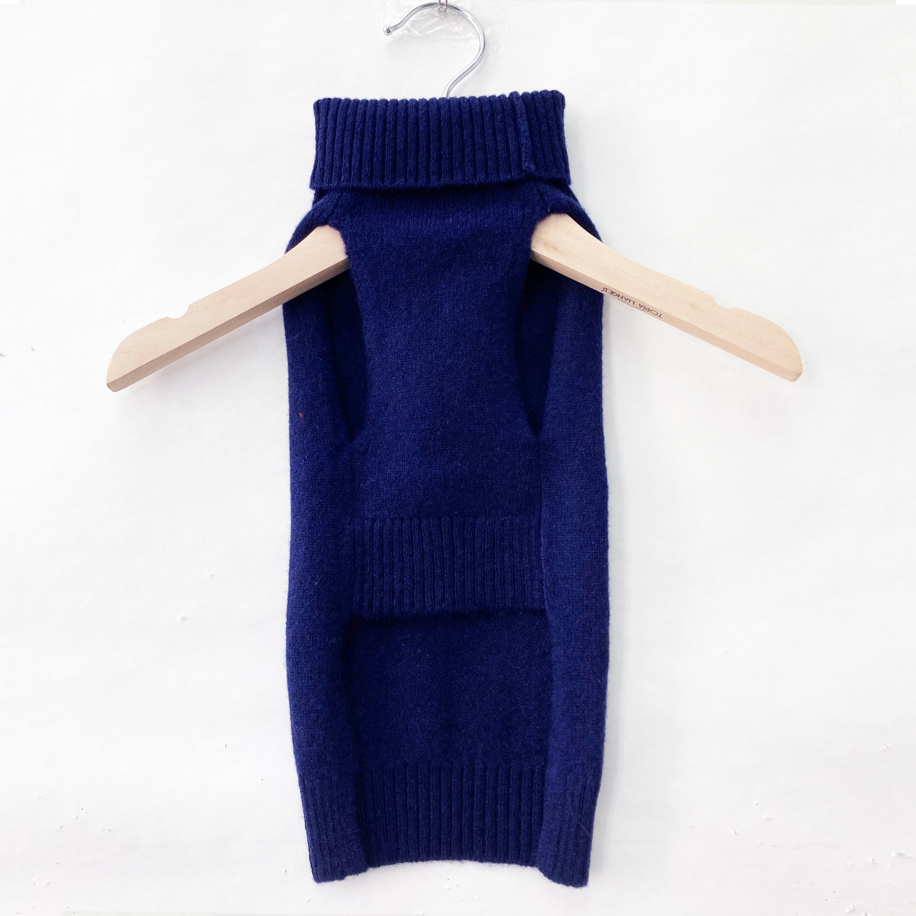 Back view of the Nooee Pet navy blue cashmere dog sweater hanging on a wooden hanger, showcasing its ribbed turtleneck and hem.