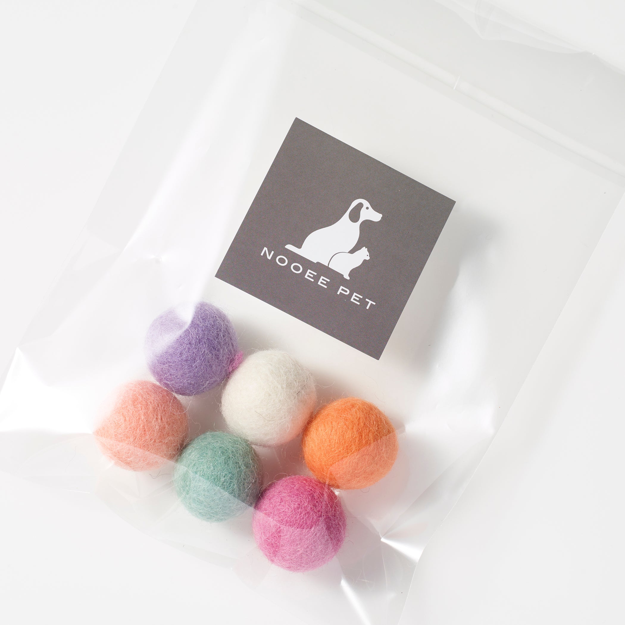 Top view of six multicolored handmade wool pet toy balls, Pastel Set, in a branded Nooee Pet pouch.