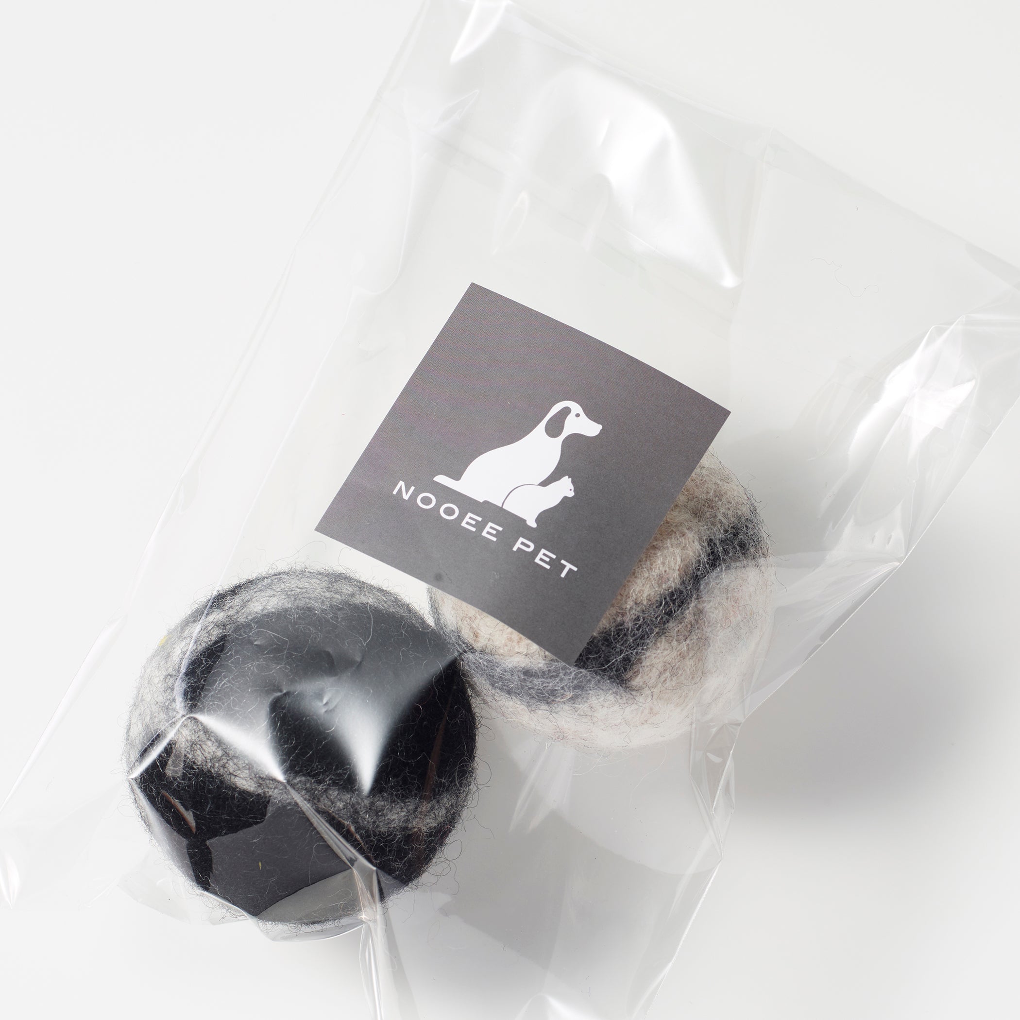 One black and one gray wool toy balls with Nooee Pet label