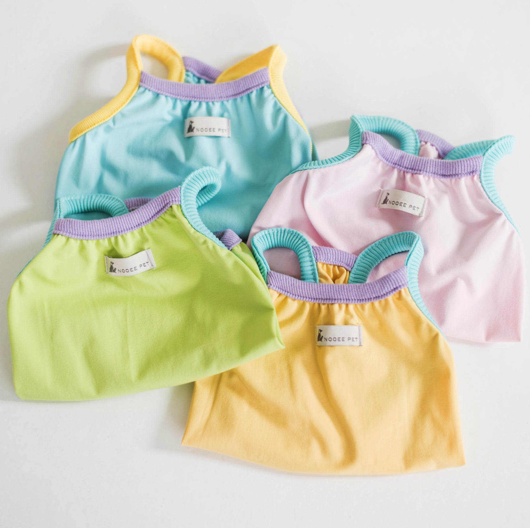 Nooee Pet CoolPaws Summer Shirt Zoey in pastel colors – lightweight cooling shirts for dogs in blue, pink, yellow, and green with colorful contrast trim. Breathable dog clothing for hot weather.