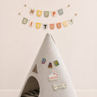 Gray felt pet cave decorated with personalized letter and birthday patches beneath a Happy Birthday banner.