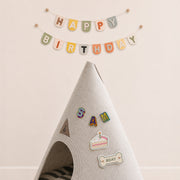 Gray felt pet cave decorated with personalized letter and birthday patches beneath a Happy Birthday banner.