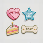 Four embroidered pet patches: pink PET ME heart, blue PAW STAR, birthday cake, and BDAY bone design.