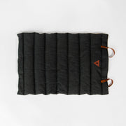 Flat-lay of Nooee Pet Jack Mat with black quilted fabric, vegan leather handles, and stitched Nooee Pet logo patch on the corner.