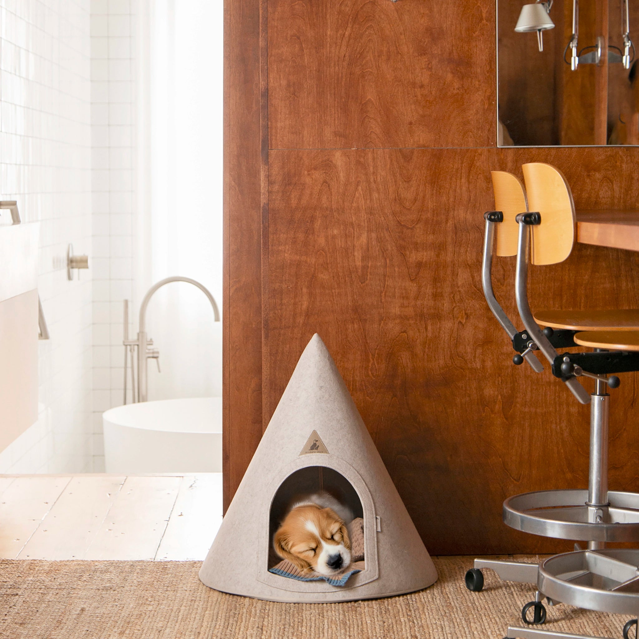 Lifestyle image of a dog resting inside the Nooee Pet Cave Lucy (M) in a home setting.