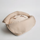 Top view of the Nooee Pet Lola Car Seat in cream nylon, showcasing its soft padded structure and inner safety tether on a removable fleece cushion.