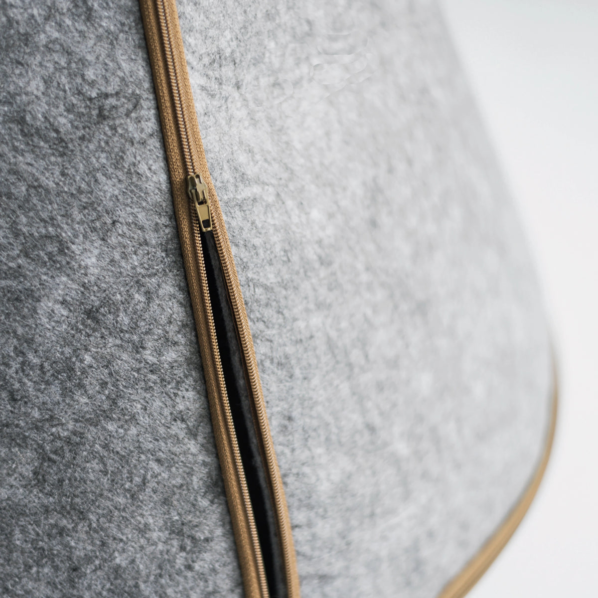 Close-up of the zipper detail on the gray Nooee Pet Toby felt dog cave