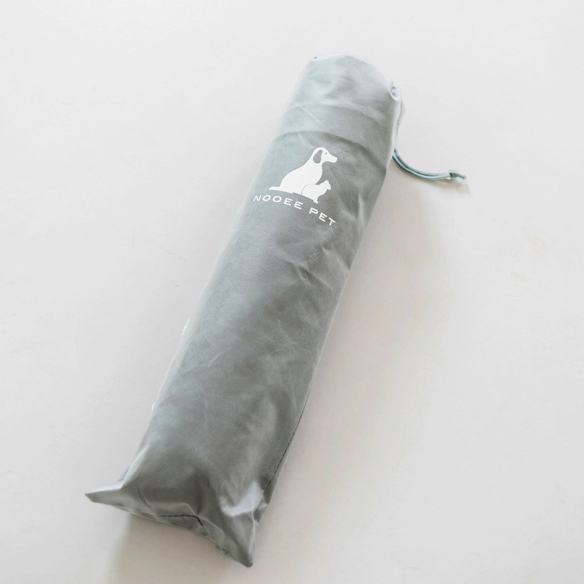 Nooee Pet Cave Lucy (M) Gray rolled up inside its compact carrying bag, highlighting its travel-friendly design