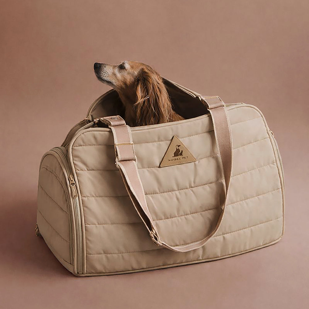 Dog resting inside the Nooee Pet Oliver carrier, a padded everyday dog carrier designed for travel and easy cleaning.