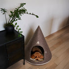 Brown Nooee Pet felt cave with a small poodle resting inside in a modern home
