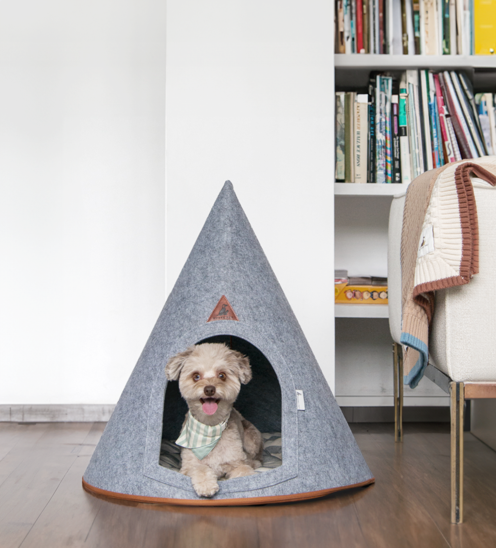Small dog resting inside a gray Nooee Pet felt dog cave bed in a modern home