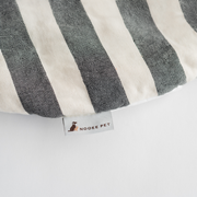 Close-up of the Nooee Pet Replacement Cushion in a black and cream stripe pattern, featuring a woven Nooee Pet brand label on soft cotton fabric.