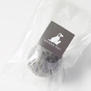 Black wool toy ball in clear packaging