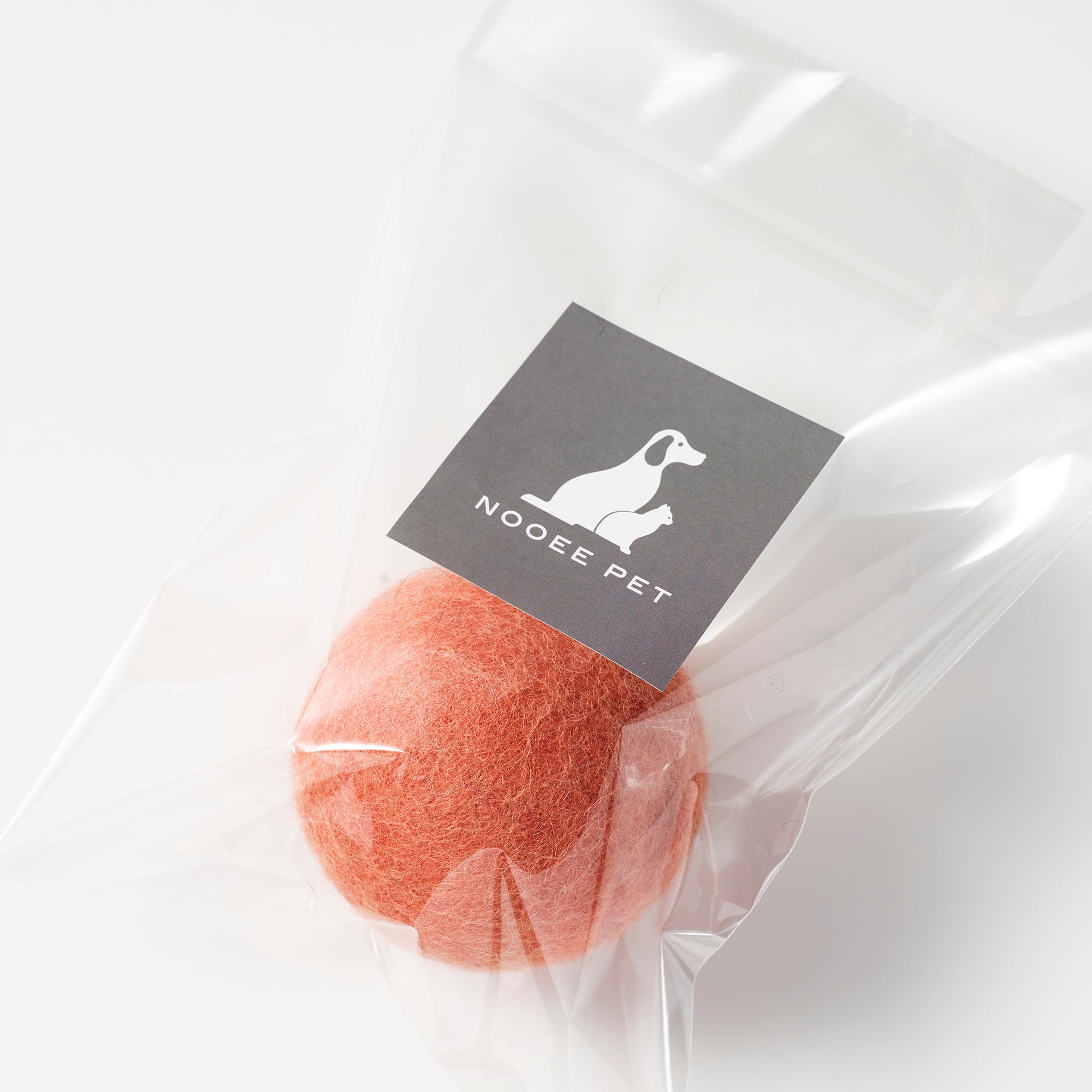 Orange wool toy ball in clear packaging