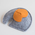 Gray felt elephant-shaped toy with a contrasting orange ear, displayed on a white background.