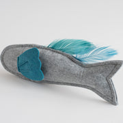 Gray felt fish-shaped toy with a blue felt fin and matching feather tail, displayed on a white background.